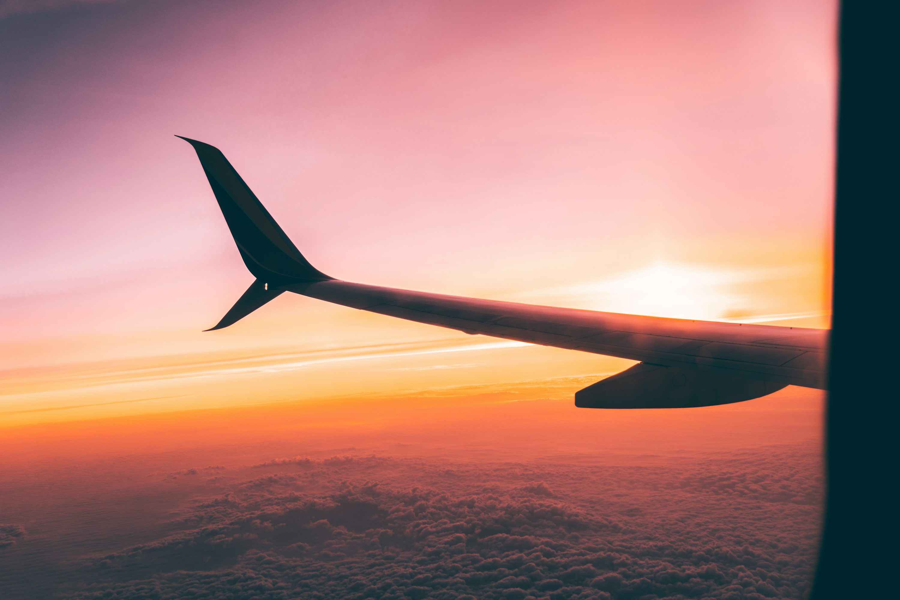 Airplane wing view at sunset